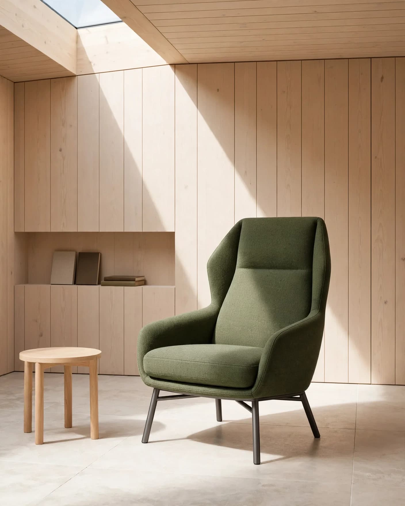 Same moss-green reading chair staged at full scale in a warm timber architectural interior