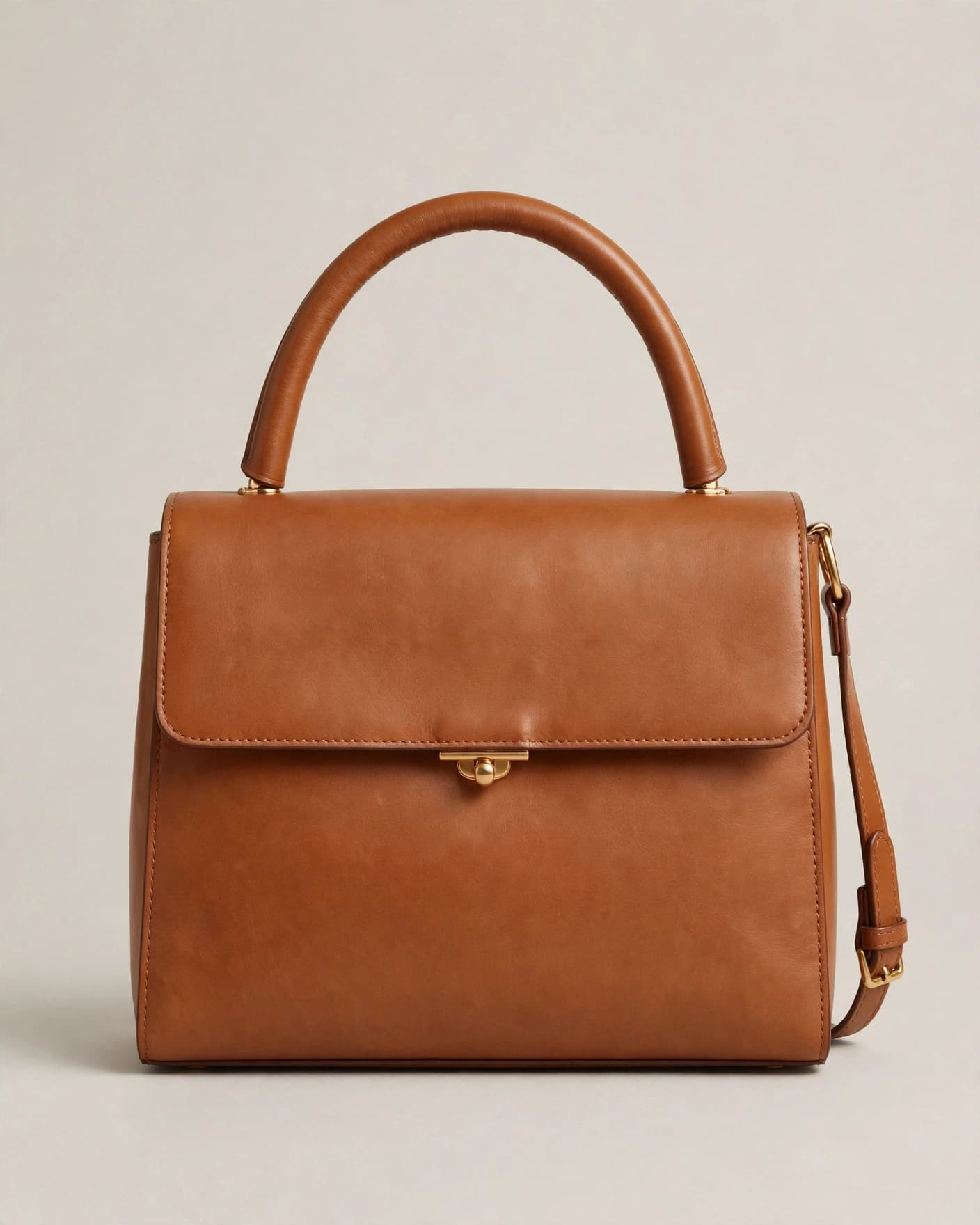 Tan leather handbag photographed on a plain neutral ecommerce background