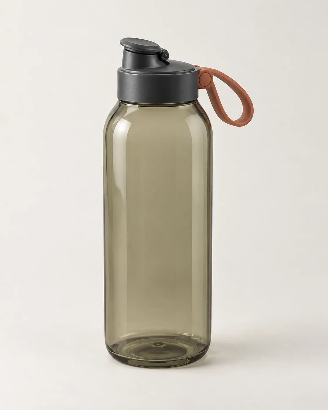 Transparent smoke-olive active bottle with a charcoal cap and terracotta carry loop on a warm neutral product background